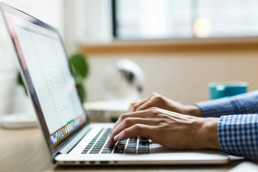 Hands typing on a laptop running cloud accounting software