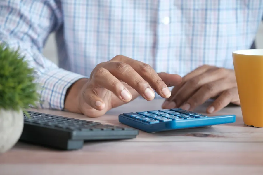 An accountant working through figures on a calculator at a desk